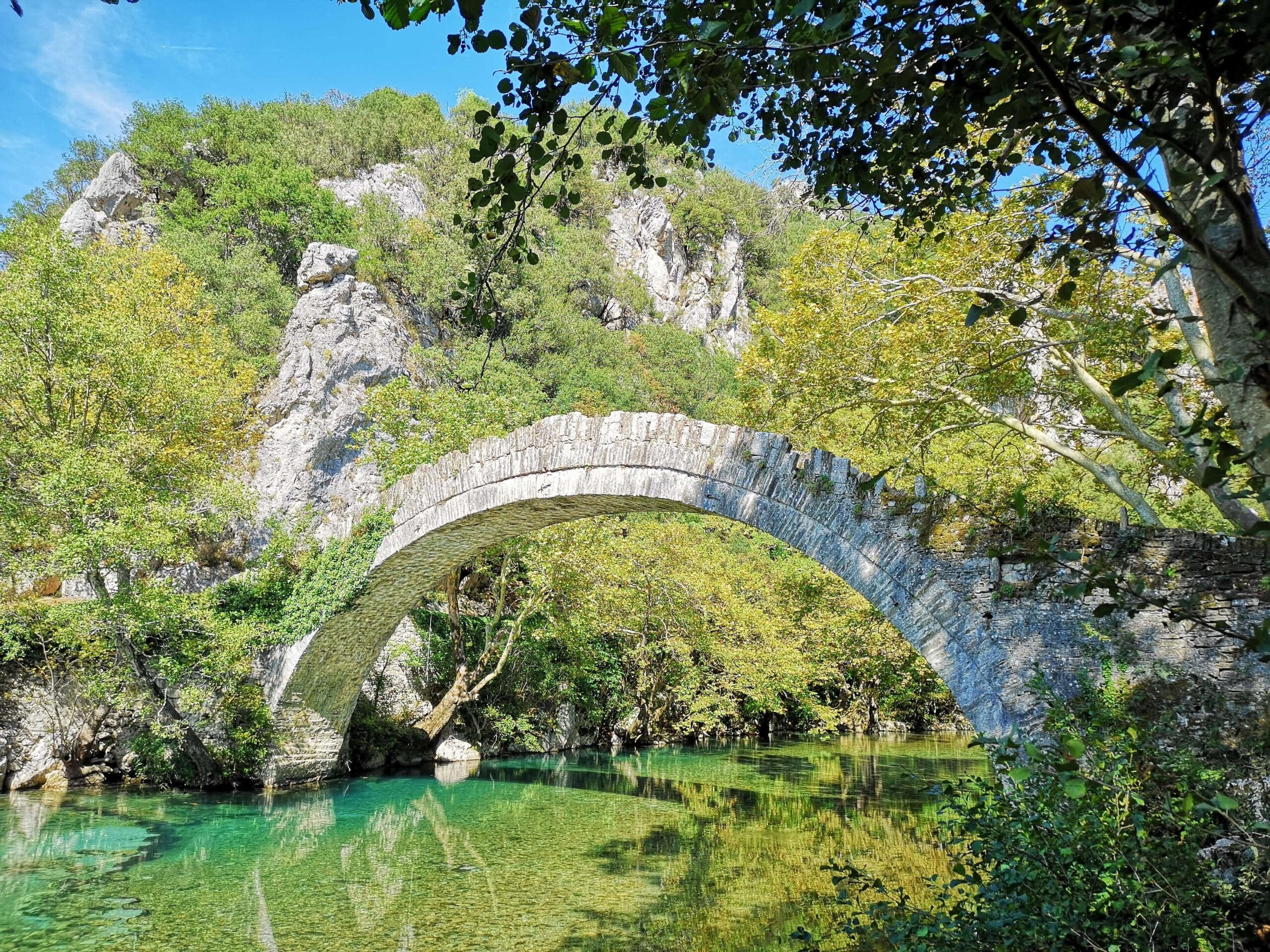 A stone bridge over a river in the mountains of Zagori, crossed by Slow Cyclists.