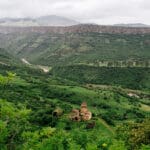 An Armenian monastery, visited by Slow Cyclists, against a backdrop of mountains and valleys