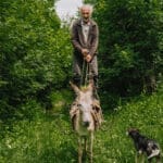 A farmer standing on his donkey in the Armenian Highlands, where Slow Cyclists explore