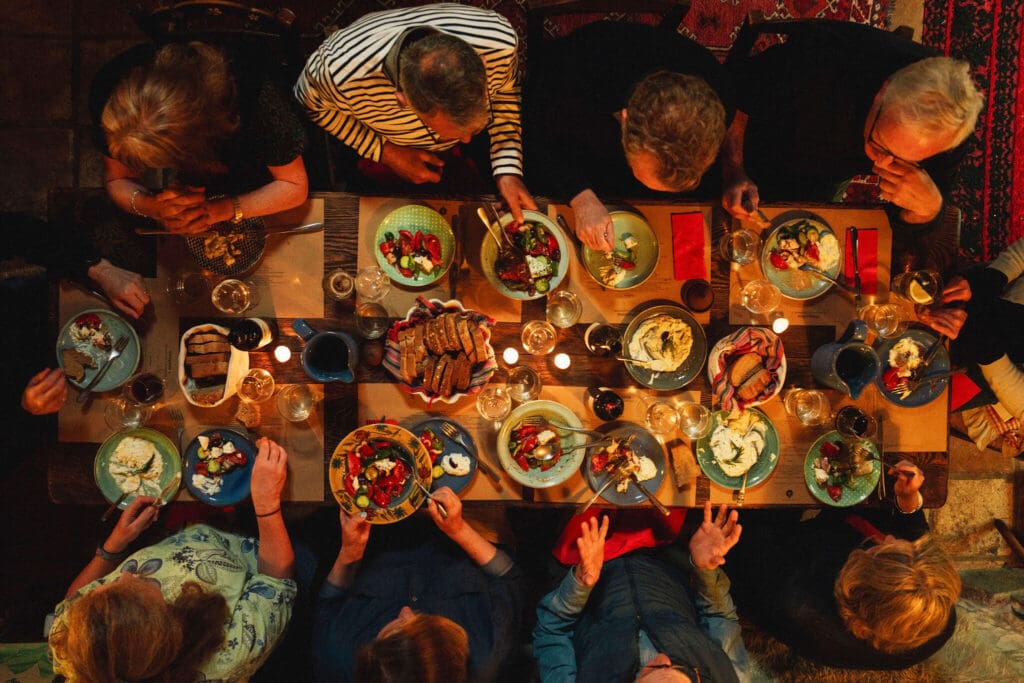 Slow Cyclists at a dinner table in Zagori, Greece, eating a Greek feast.