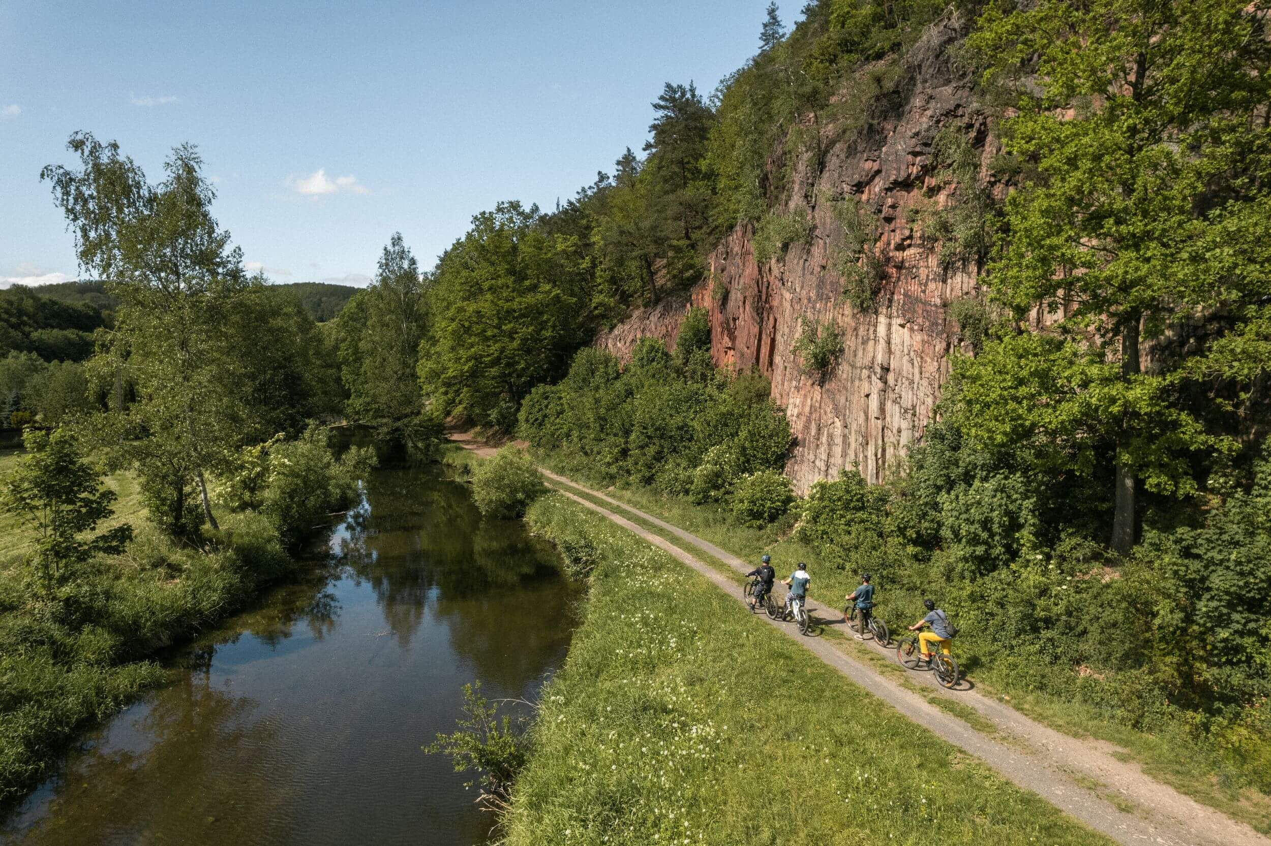 Slow Cyclists riding along a river in a gorge in Lower Silesia, Poland.