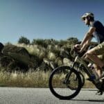 A Slow Cyclist riding past rock formations in Portugal's Douro region.