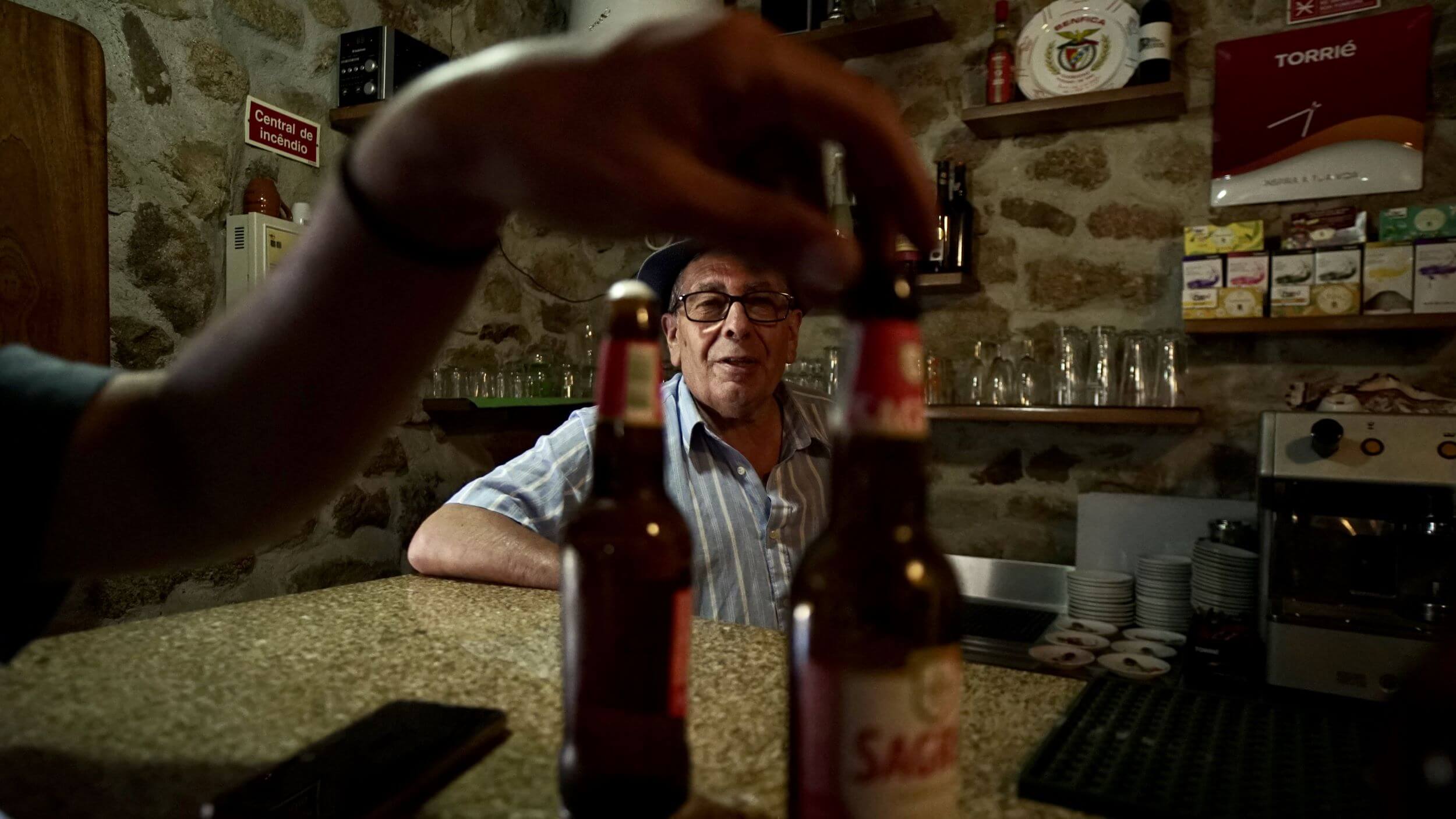 A bar owner serving beer to Slow Cyclists in the Douro region of Portugal