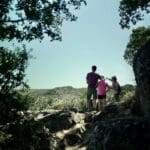 Slow Cyclists looking through the trees towards the mountains of the Douro Valley, Portugal.