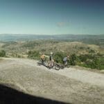 Three Slow Cyclists paused on their bikes to admire the valleys and mountains in Portugal's Coa region.