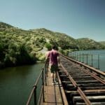 A Slow Cyclist walking across a bridge over the Coa River in Portugal.