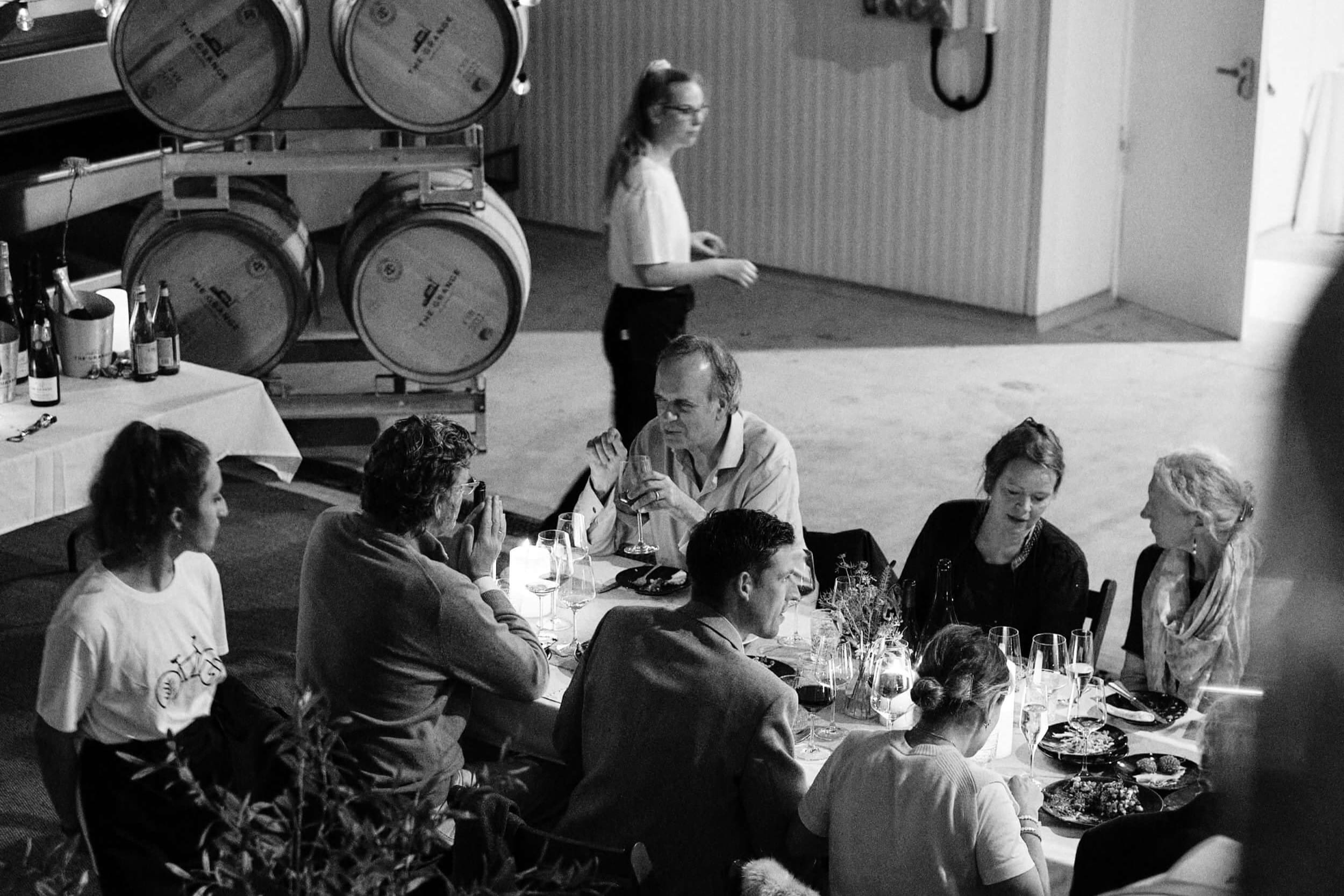 Guests eating food from Imad's Syran Kitchen among wine barrels at The Grange at The Slow Table event